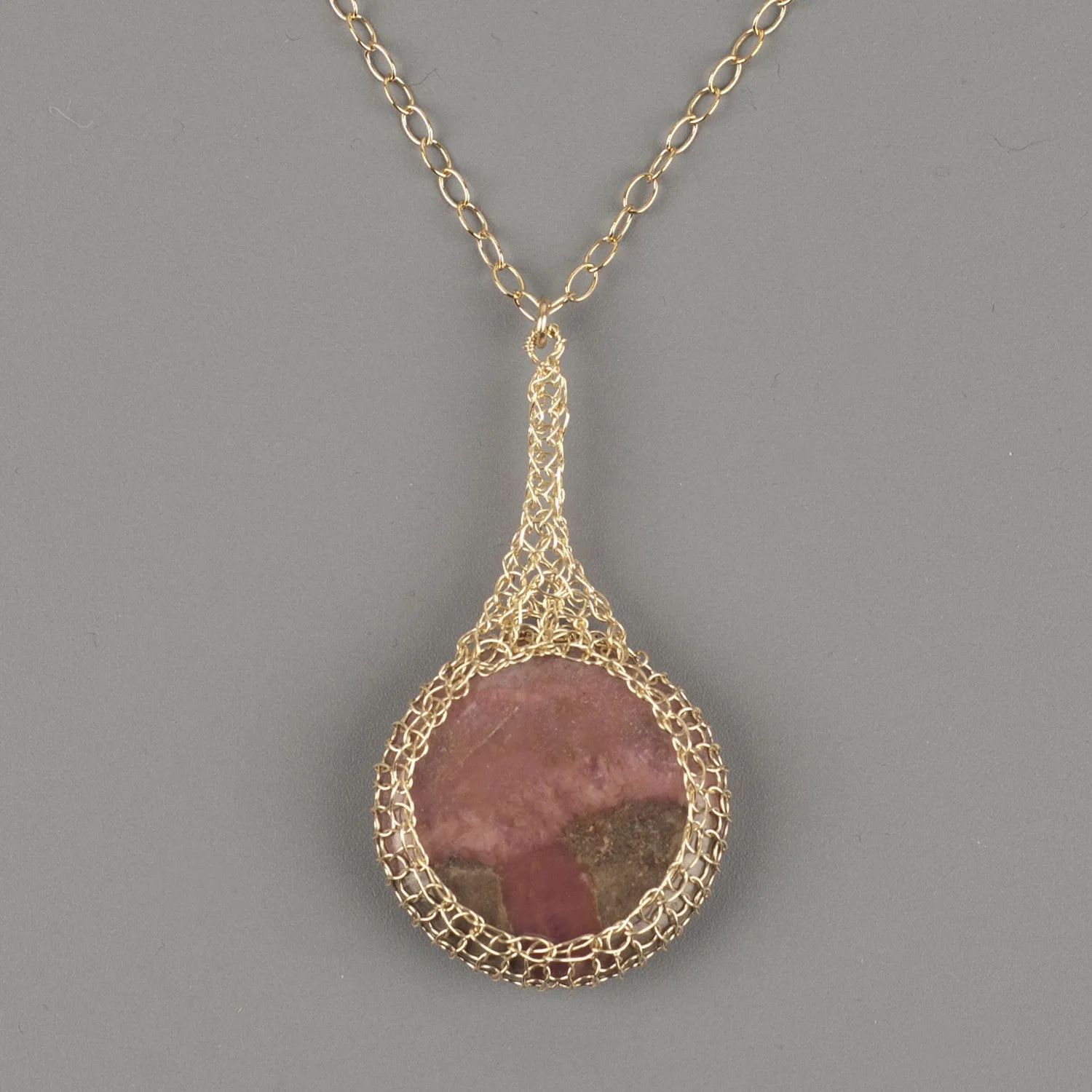 Large round Rhodonite pendant necklace, nested in gold wire crochet