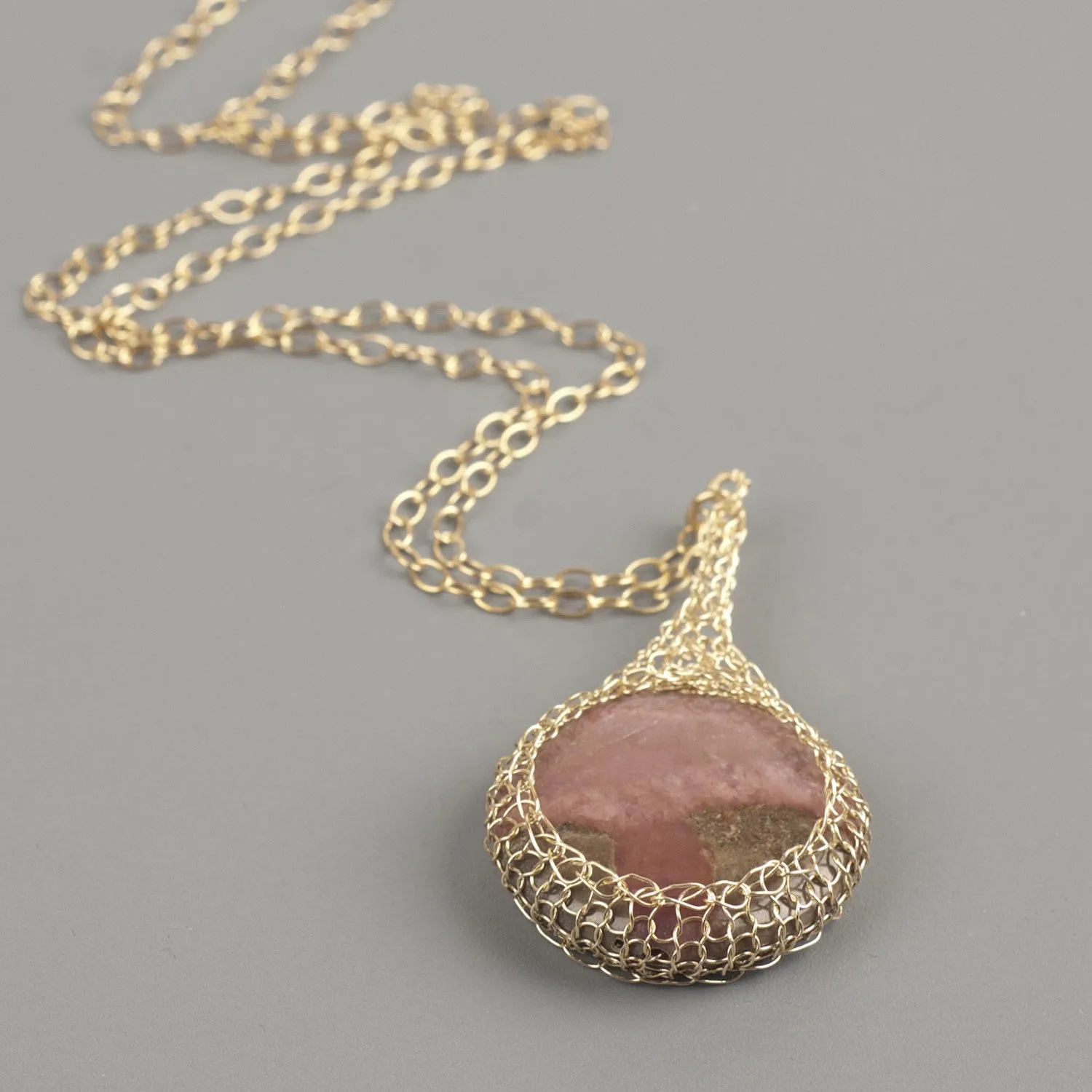 Large round Rhodonite pendant necklace, nested in gold wire crochet