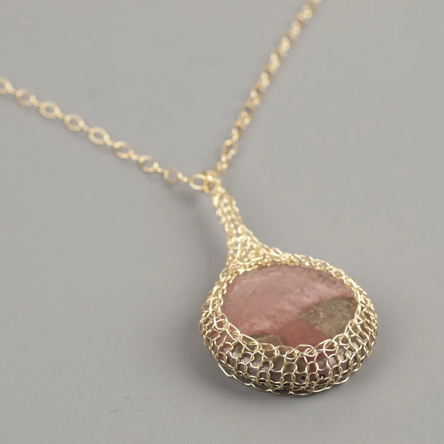 Large round Rhodonite pendant necklace, nested in gold wire crochet